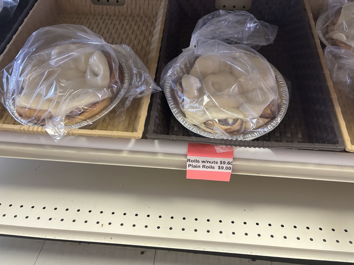 Trays of fresh cinnamon rolls with white icing in bags