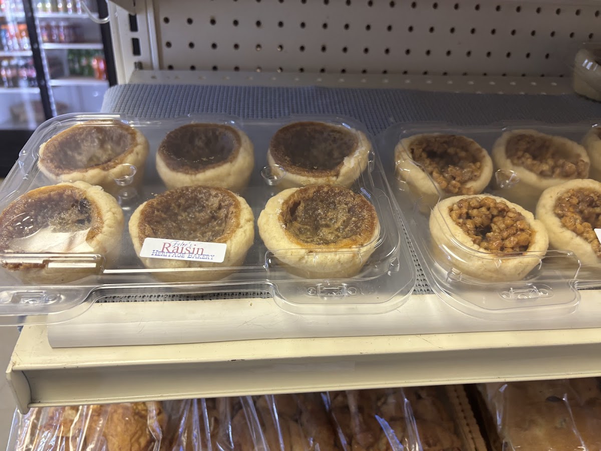 Rows of fresh butter tarts with golden pastry and rich fillings including raisin and plain varieties